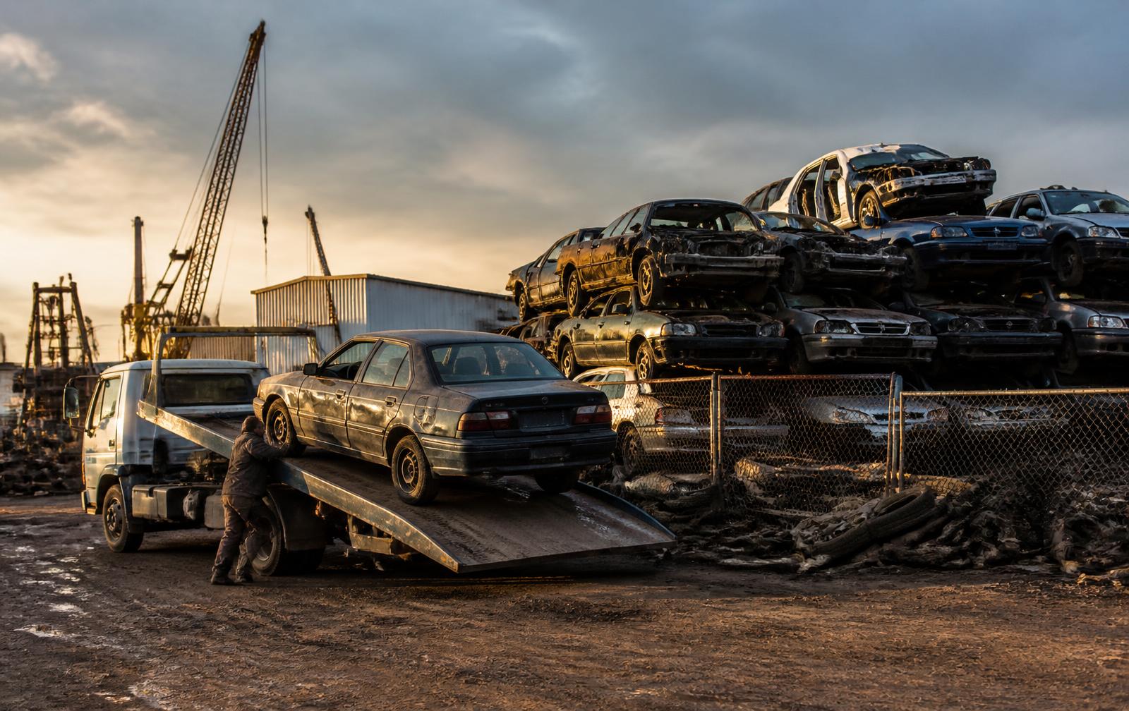 Acme tow truck loading a junk car at the Pontiac, Michigan salvage yard